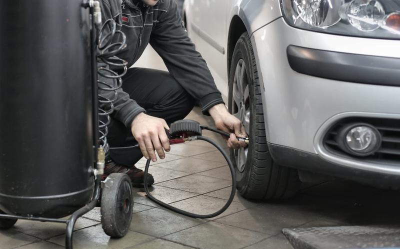 Checking tyre pressure on a car