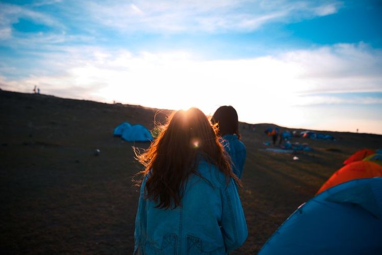 Festival campsite with tents arranged in a field at sunset