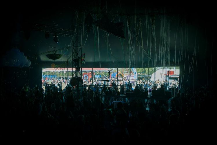 Small festival stage with crowd enjoying live music outdoors